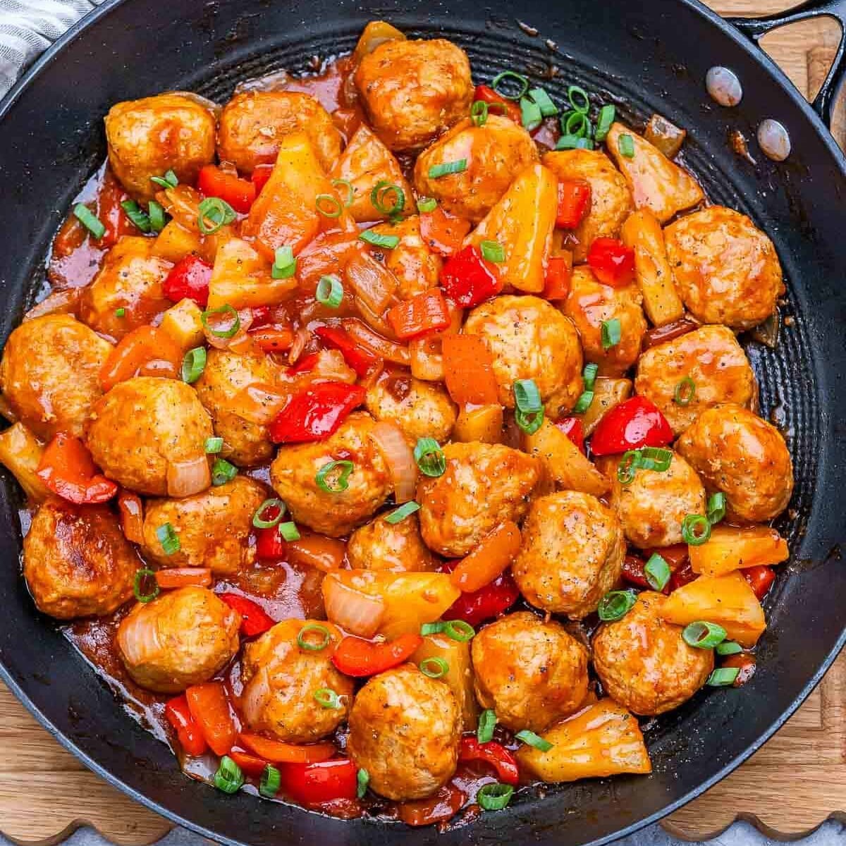 Almôndegas de frango douradas ao lado de molho agridoce de abacaxi, tomate e vinagre de arroz, com panko crocante ao fundo