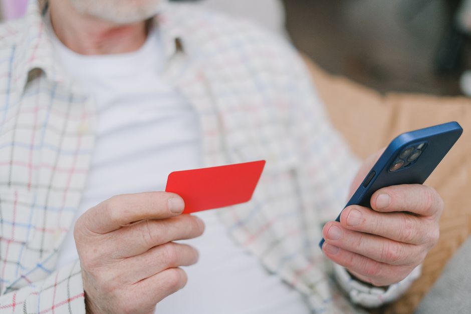 Idoso praticando exercício de equilíbrio em prancha instável enquanto segura smartphone com o app Mais Equilíbrio