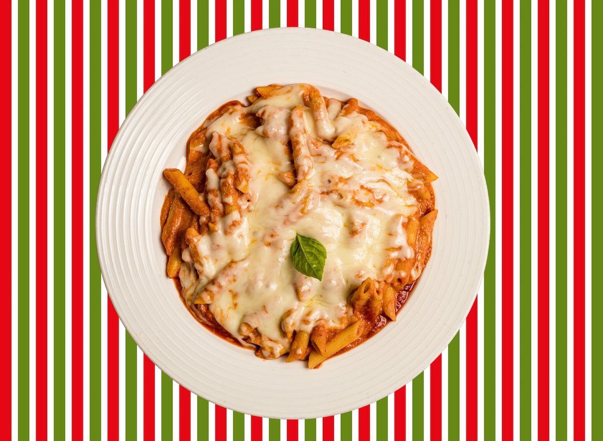 Prato de baked ziti com massa al dente, molho vermelho‑cremoso, queijo gratinado e brócolis verdes ao lado