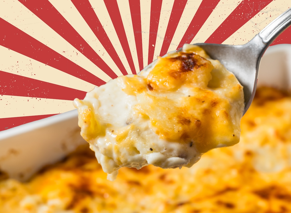 Batata gratin dourada em prato, acompanhada de salada verde e garrafa de água ao lado