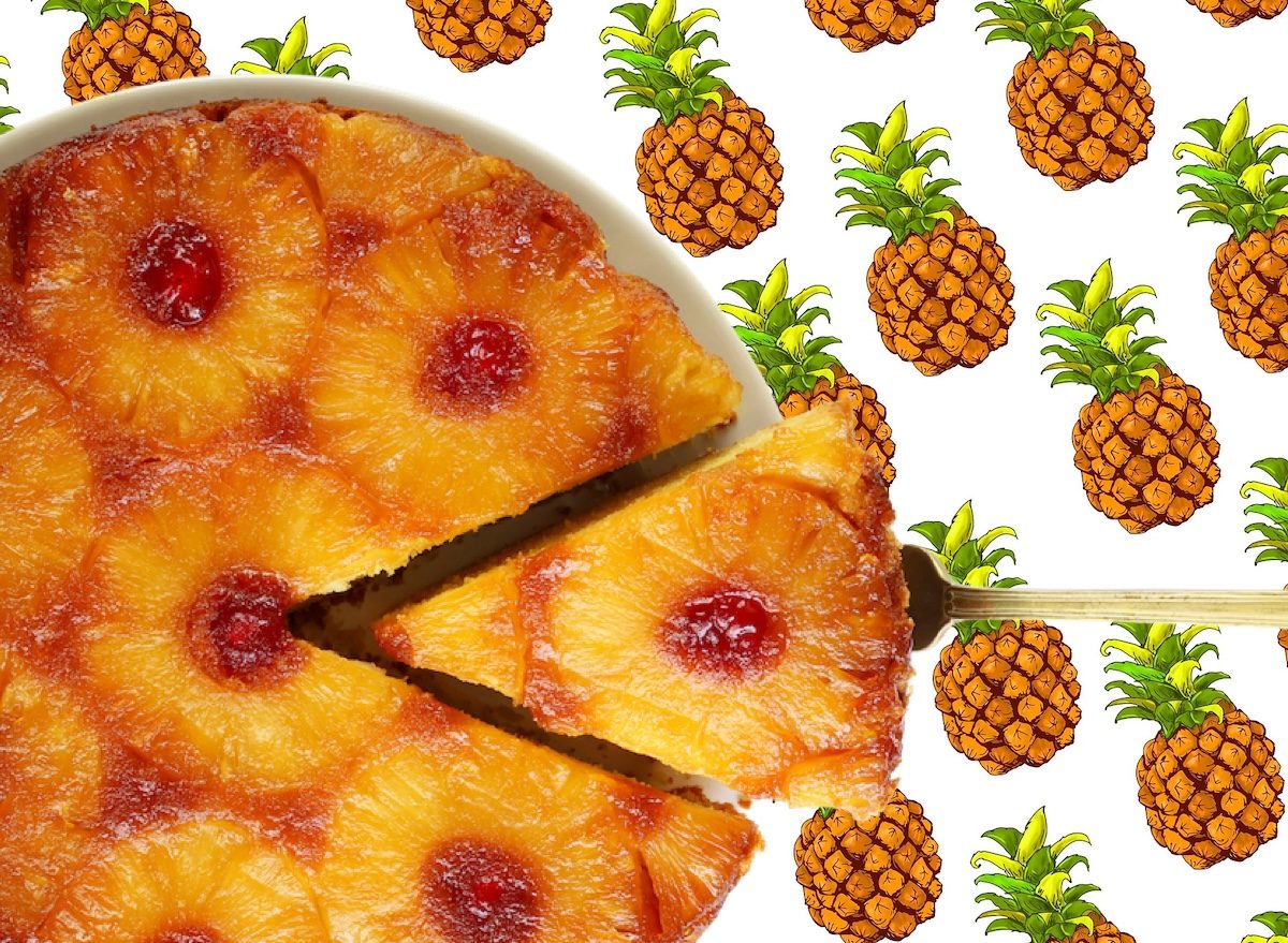 Fatias de bolo de abacaxi invertido ao lado de iogurte grego, morangos frescos e uma colher de mel