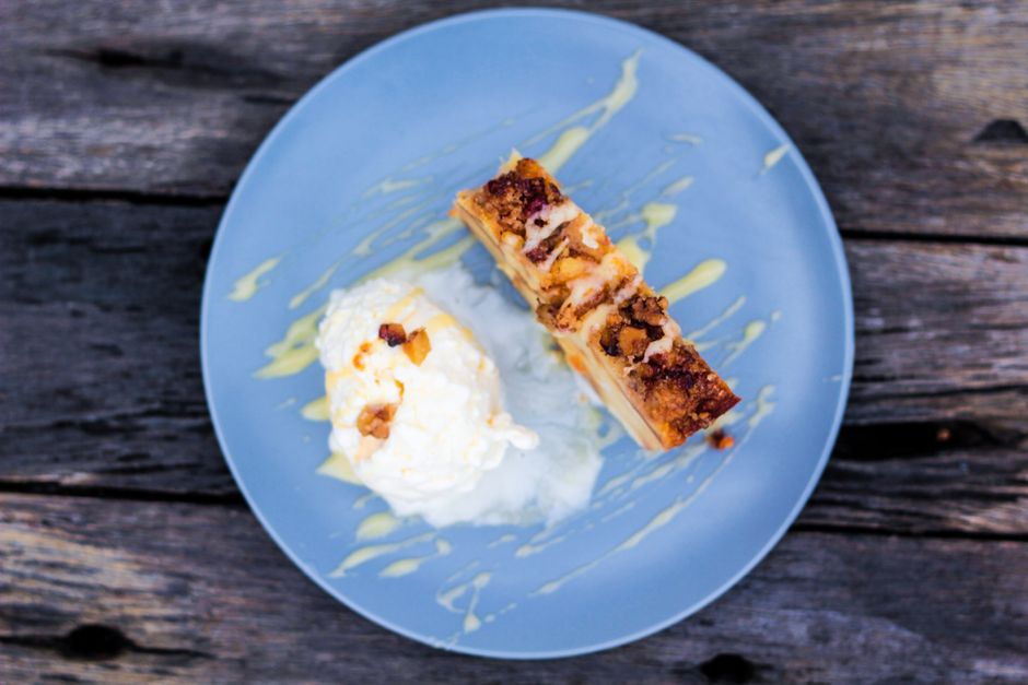 Fatias de bolo de maçã ao contrário com maçãs caramelizadas brilhando sobre a camada úmida, decorado com tâmaras picadas e fio de óleo de coco