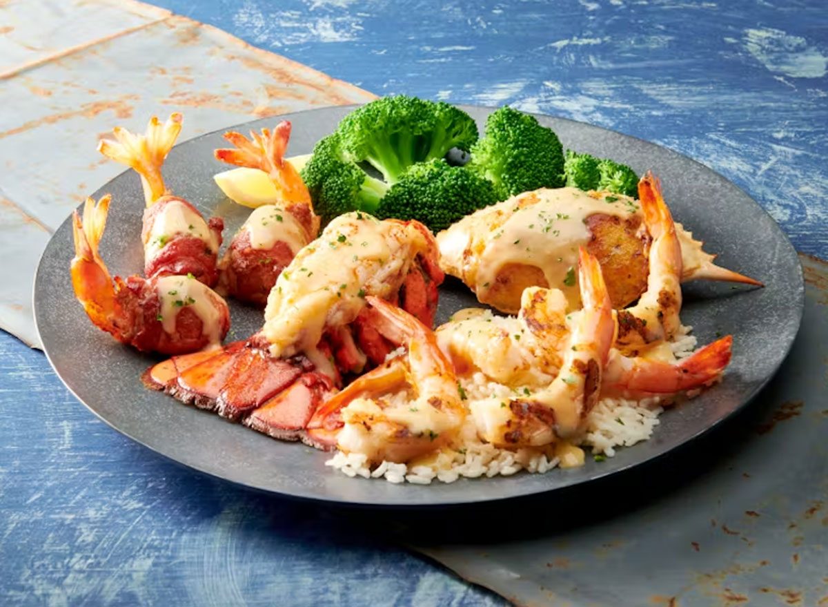 Um prato de lagosta grelhada servida com salada de folhas verdes e legumes frescos