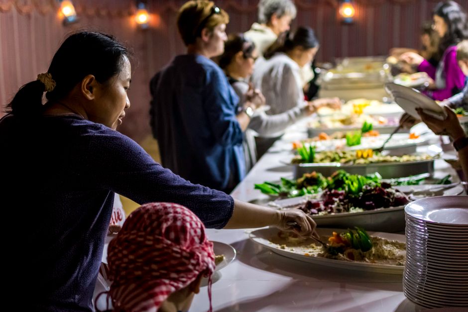 Prato colorido com sushi, sashimi, legumes ao vapor e salada de algas, tudo disposto em bandejas de buffet asiático