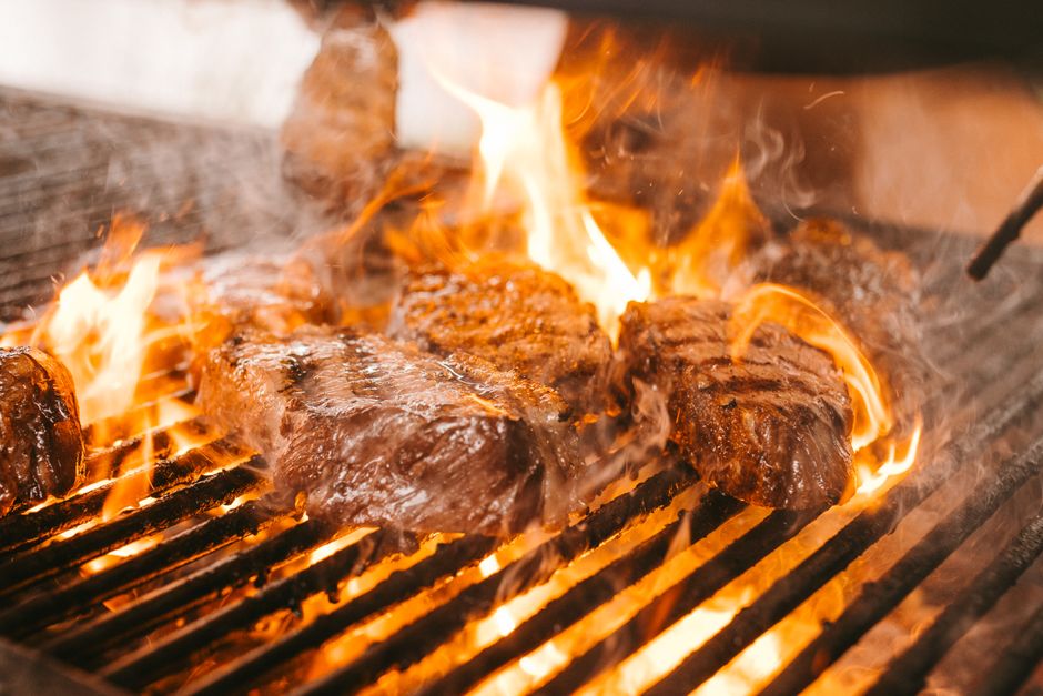 Uma vasilha com burnt ends crocantes e macios, com uma fatia de pão e uma xícara de bebida saudável ao lado