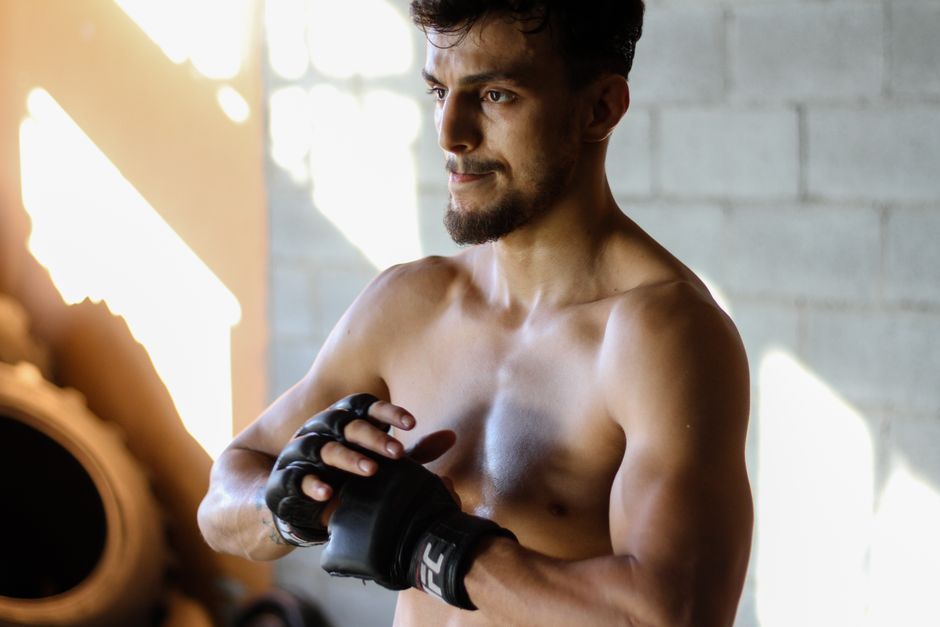 Pessoa em academia segurando garrafa C4 Sport Uncle Samberry, com barra de pesos e placa Walmart ao fundo