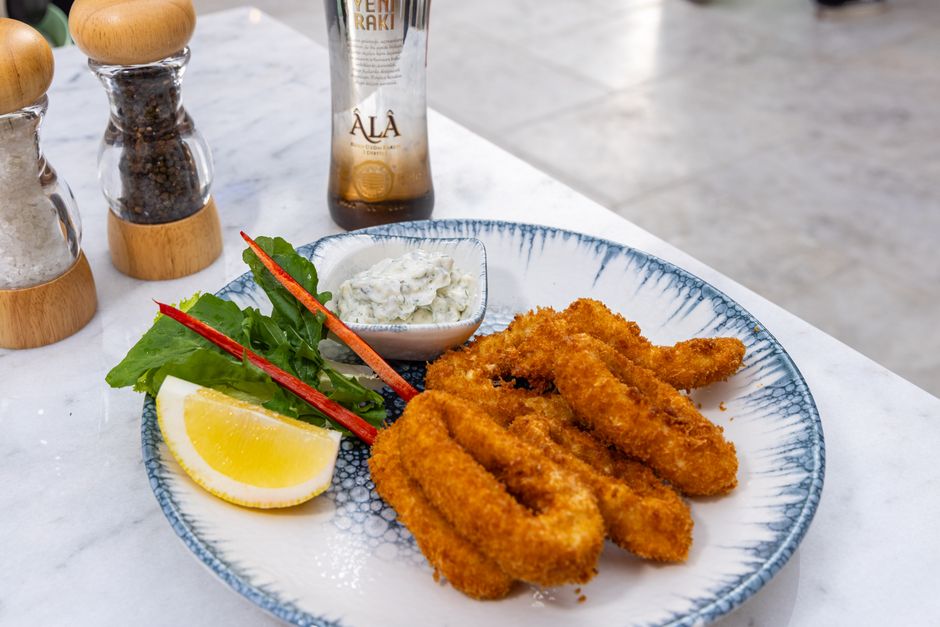 Camarões fritos e batatas crocantes em uma assadeira de aço inoxidável