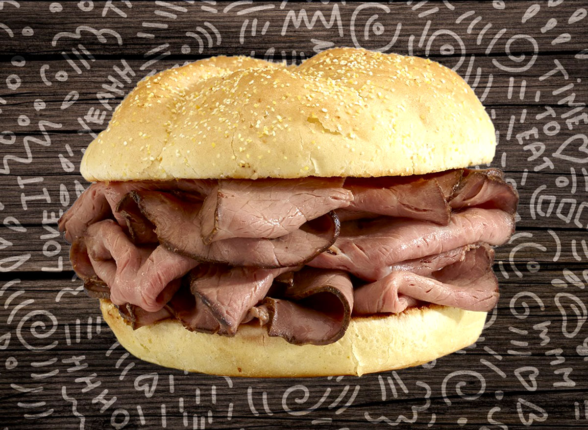 Corte de carne bovina suculenta fatiada sobre tábua de madeira, acompanhada de ervas frescas e utensílios de cozinha
