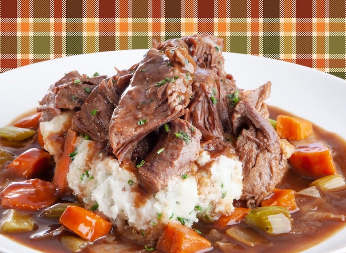 Prato de carne assada na panela, com legumes coloridos, acompanhada de salada verde e garrafa de água