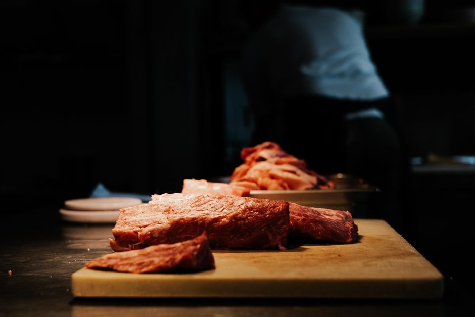 Variedade de pacotes de carne moída ao lado de uma balança, legumes frescos e um garfo, sugerindo escolhas saudáveis