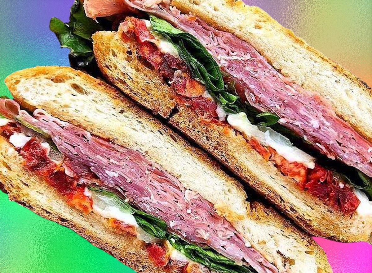 Fatias finas de peito de peru, peito de frango e bresaola ao lado de folhas de rúcula e quinoa