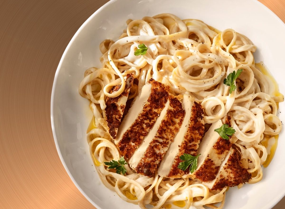 Um prato de Chicken Alfredo com massa fresca, frango grelhado e molho cremoso equilibrado