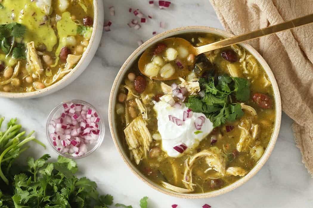 Frigideira com frango dourado, feijão verde e pimentões, cobertos por molho de chili e salpicados com coentro fresco