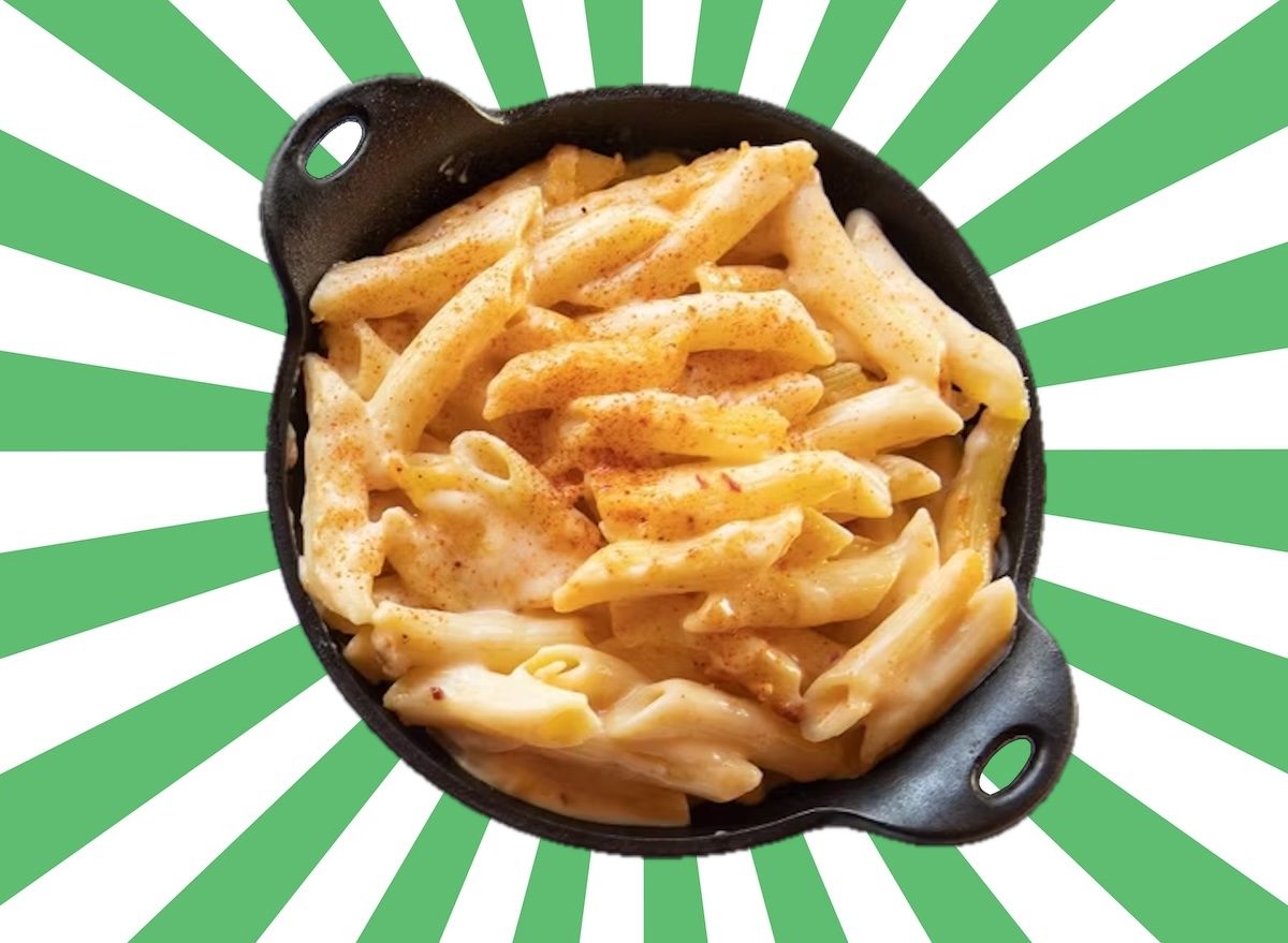 Prato de lasanha congelada sendo aquecido no micro-ondas ao lado de frutas vermelhas congeladas e um copo de água