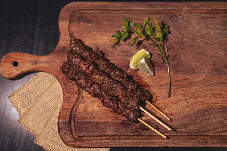 Picanha suculenta grelhando em uma churrasqueira ao lado de espetos de vegetais frescos e temperos naturais