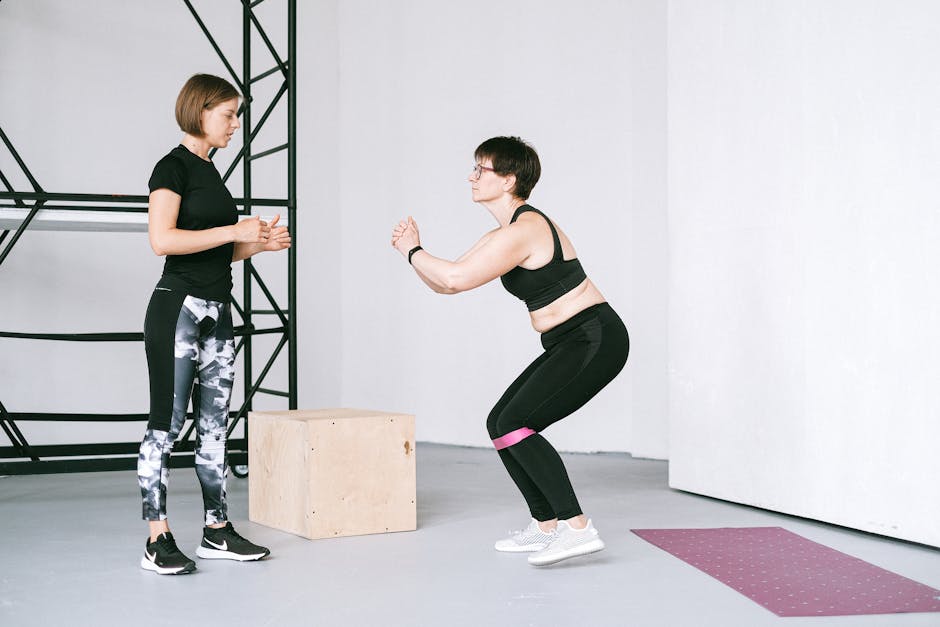 Personal trainer orientando aluno em um exercício de agachamento com halteres em uma academia moderna e iluminada