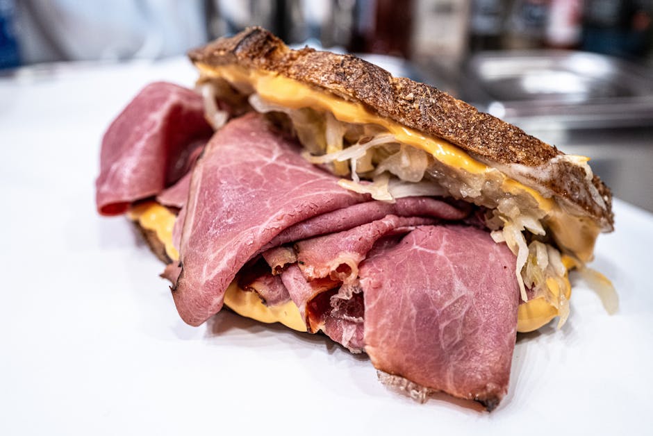 Sanduíche Reuben montado em tábua de madeira, com camadas de carne, chucrute, queijo derretido e molho especial