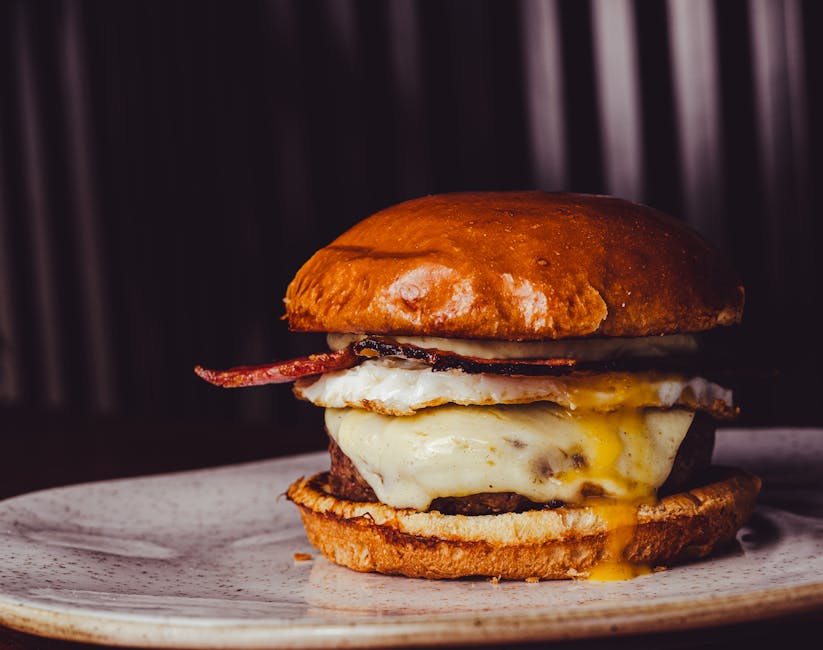 Sanduíche de ovo com bacon em pão integral, acompanhado de folhas frescas e uma xícara de café sobre uma mesa rústica