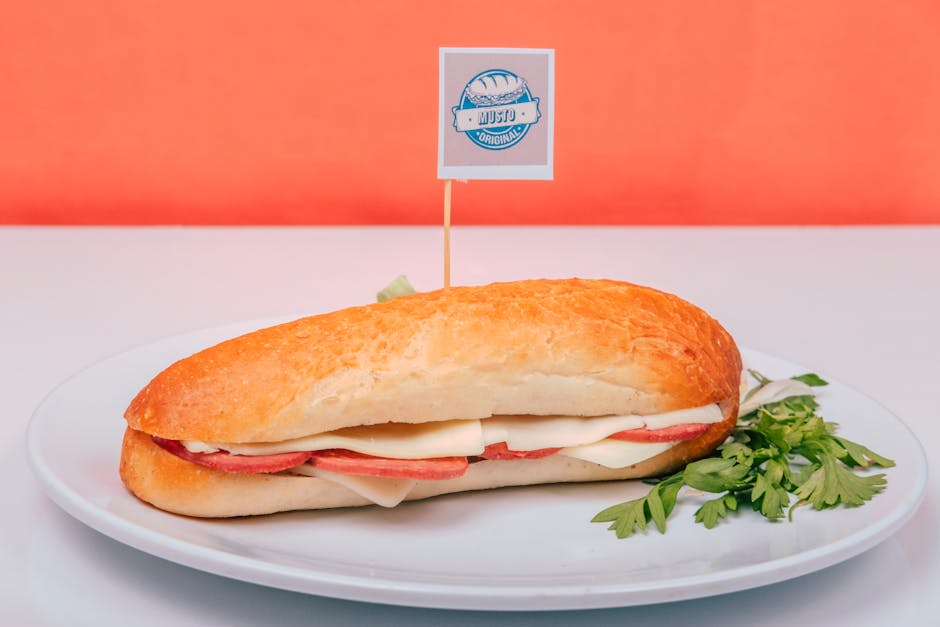 Sanduíche italiano montado em pão integral com fatias de presunto cru, mussarela de búfala, rúcula e tomates frescos