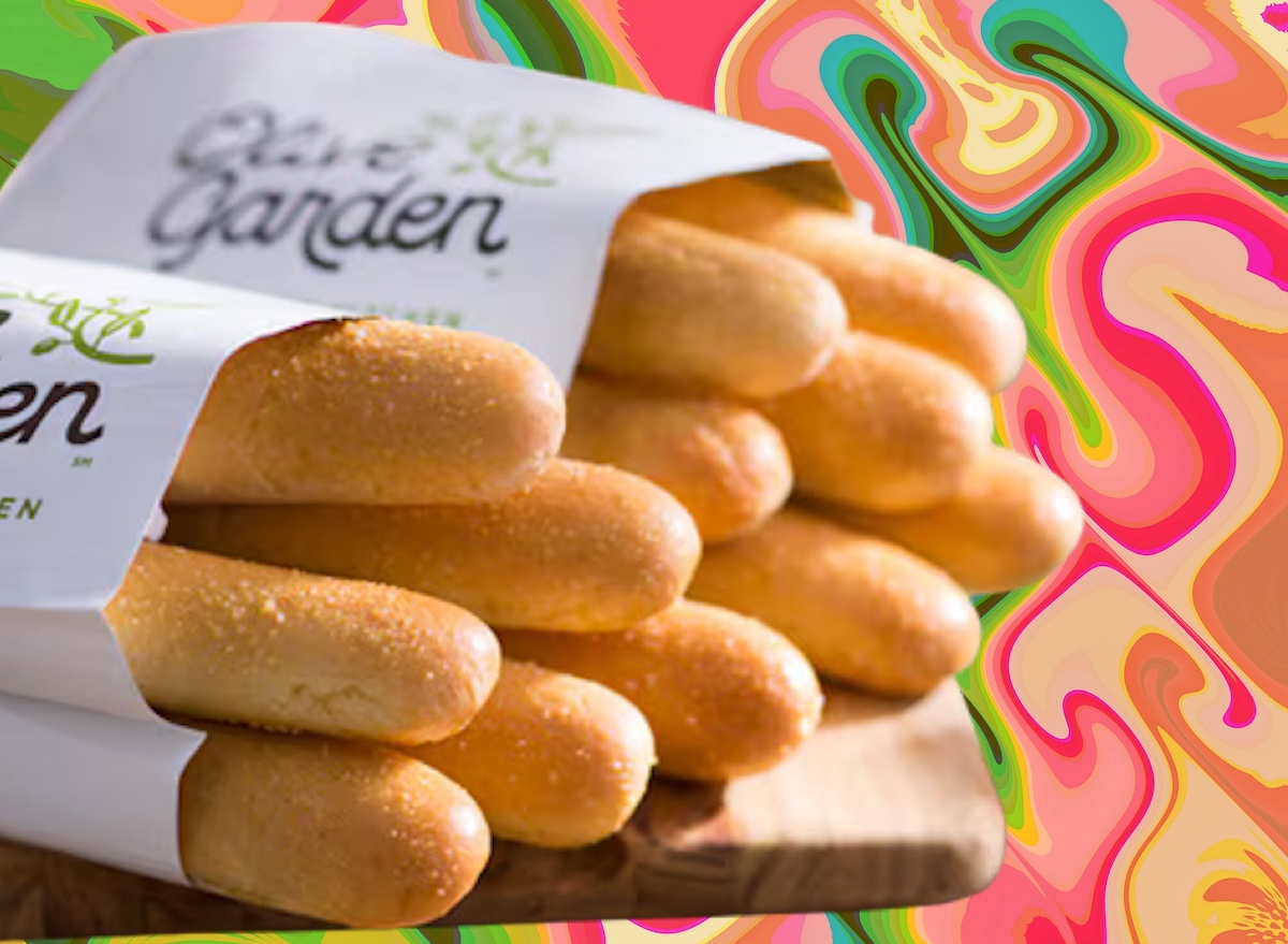 Fatias de pão integral ao lado de grãos, sementes e uma fita métrica sobre uma mesa de madeira clara