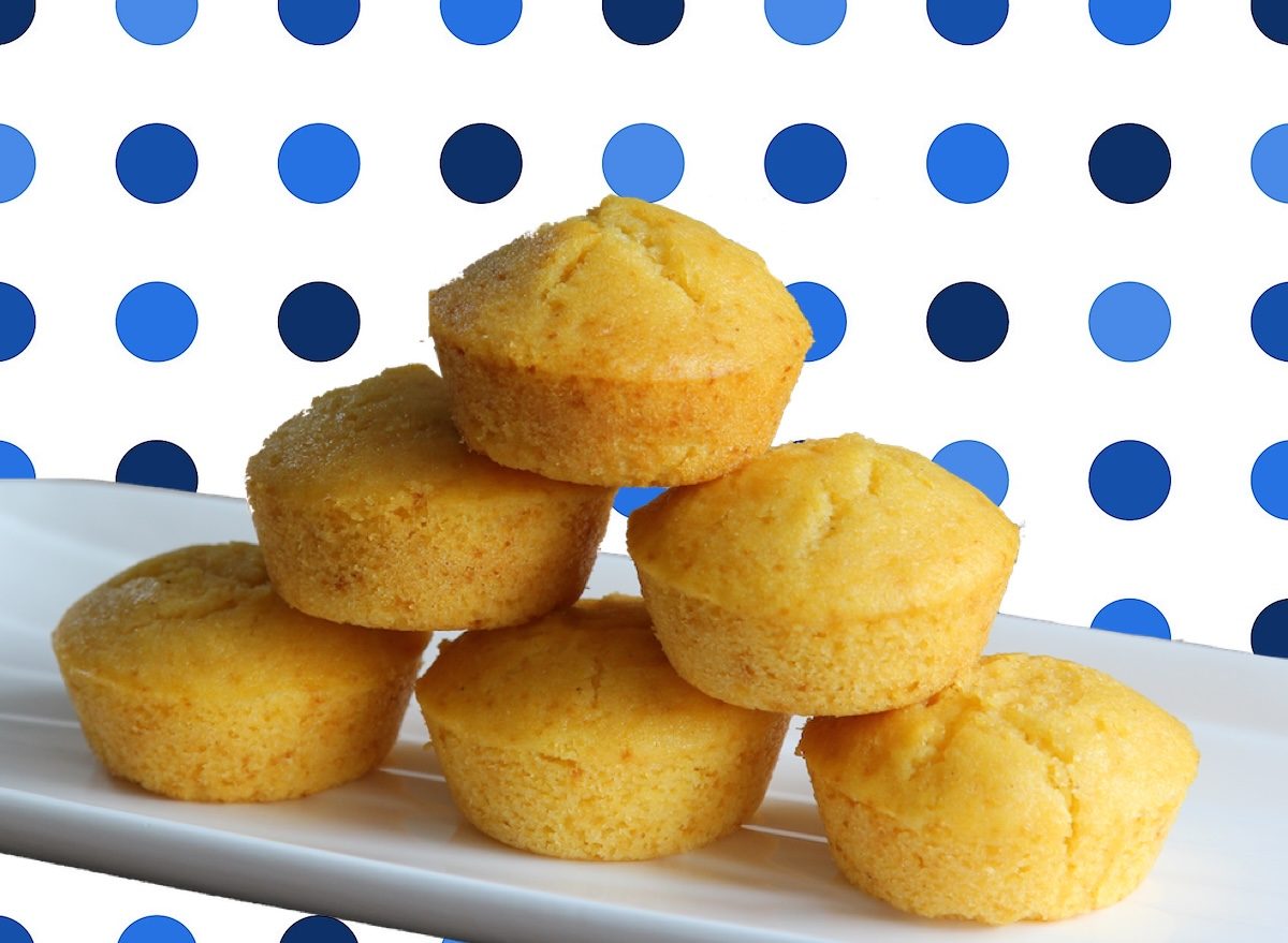 Muffins de milho dourados ao lado de uma xícara de café, com mel e uma colher de canela ao fundo