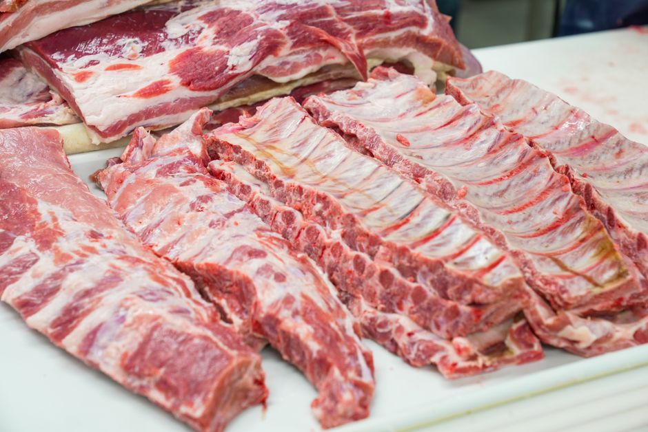 Costela bovina grelhada ao lado de salada de folhas verdes e uma balança de cozinha mostrando 200g de proteína