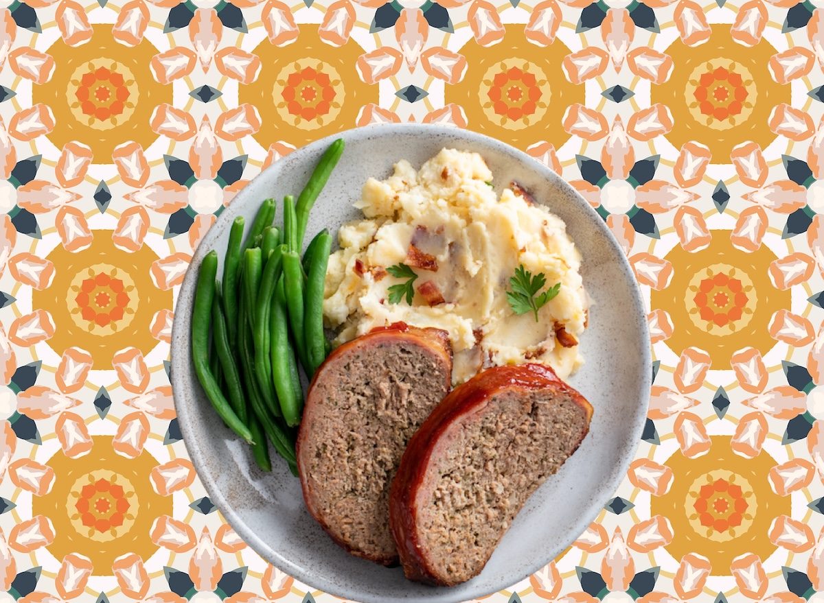 Prato rústico com peito de frango grelhado, legumes assados coloridos e quinoa ao lado, tudo disposto sobre tábua de madeira