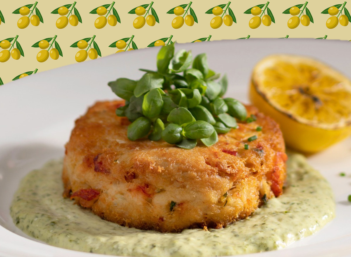 Um prato de crab cake com frango, limão e ervas frescas, destacando a textura macia e o sabor intenso