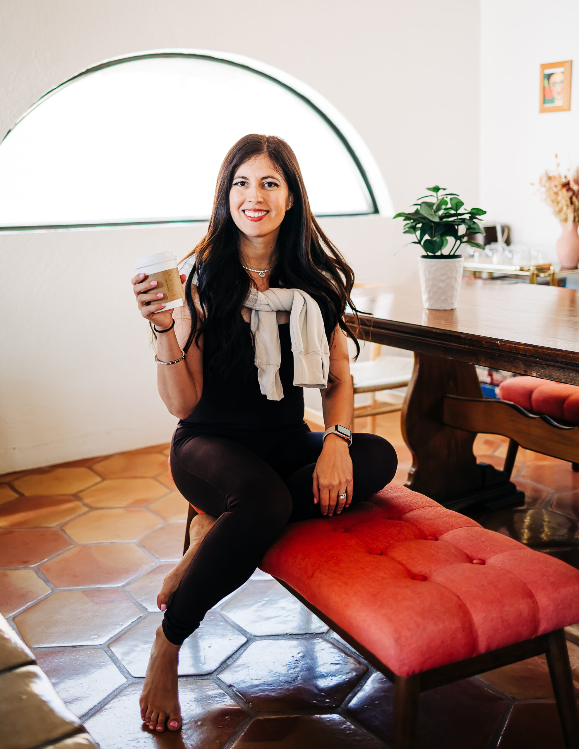 Xícara de café fumegante ao lado de suplementos minerais e um dispositivo de biohacking sobre uma mesa de madeira