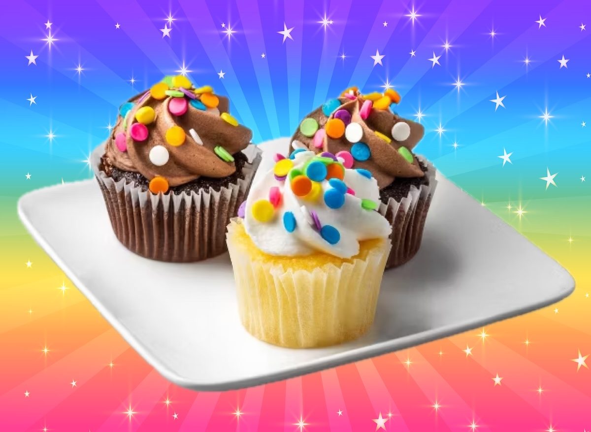 Pedaços de frutas frescas e barras de granola ao lado de cupcakes industrializados com ingredientes enumerados em rótulo