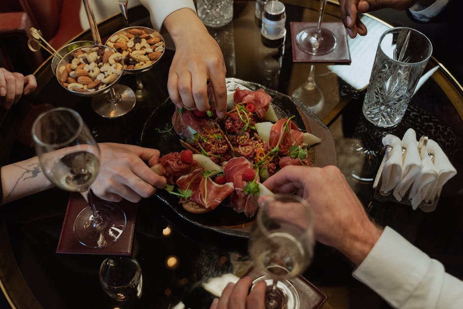 Mesa de restaurante com porções de batatas fritas, molhos cremosos e uma salada ao lado do prato principal