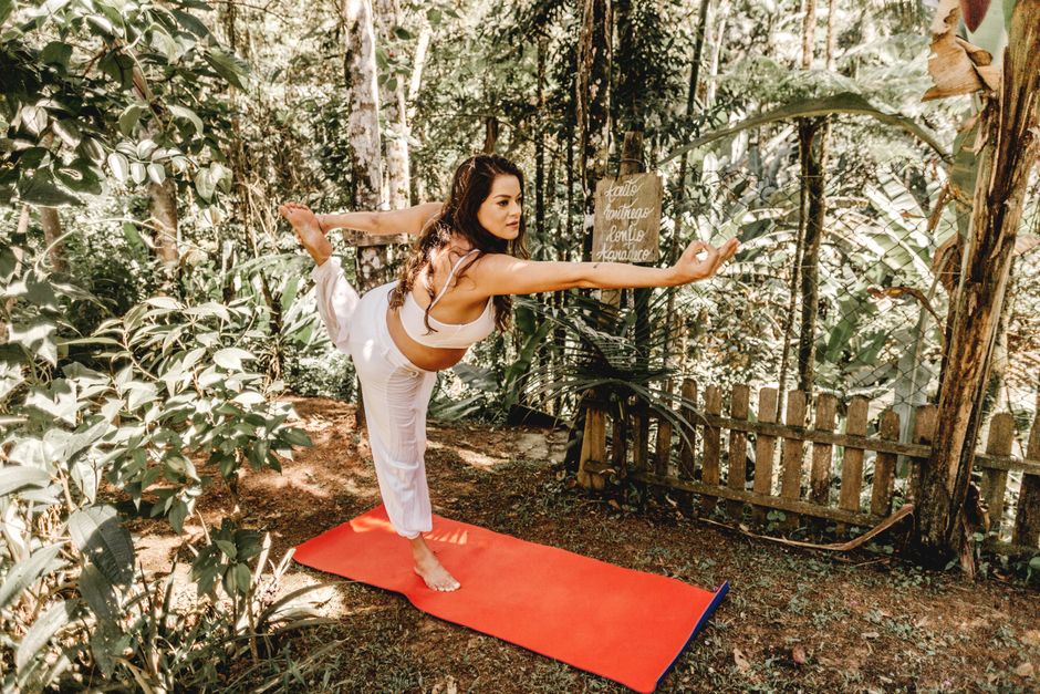 Uma pessoa sentada em uma cadeira, com os olhos fechados, elevando os calcanhares e os dedos dos pés em um ambiente de treinamento de equilíbrio