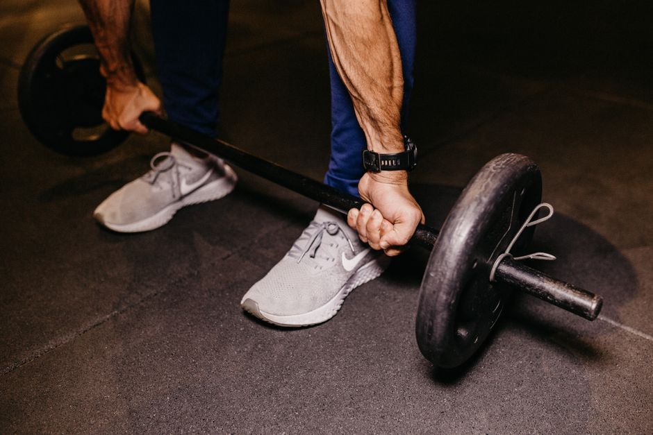 Idoso em roupas esportivas realizando agachamento, flexão inclinada, levantamento de kettlebell e remada com banda