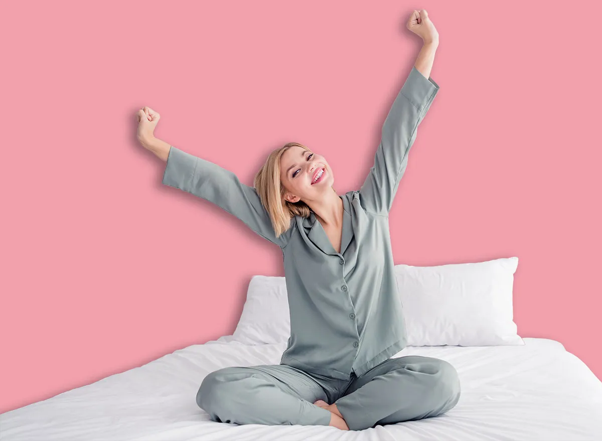 Pessoa deitada na cama, com peso na barriga e mãos segurando uma barra de treino