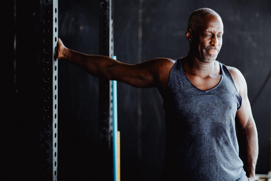 Uma pessoa executando wall push-ups, com braços estendidos e puxando-se em direção à parede