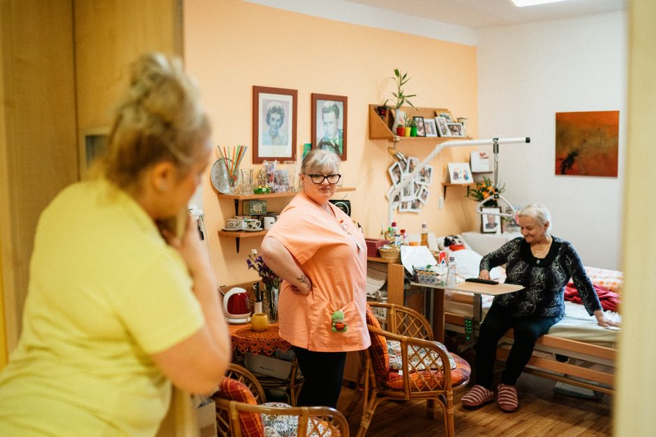 Idoso(a) de pé ao lado da parede, mão apoiada, perna elevada lateralmente, foco no abdutor com leve resistência