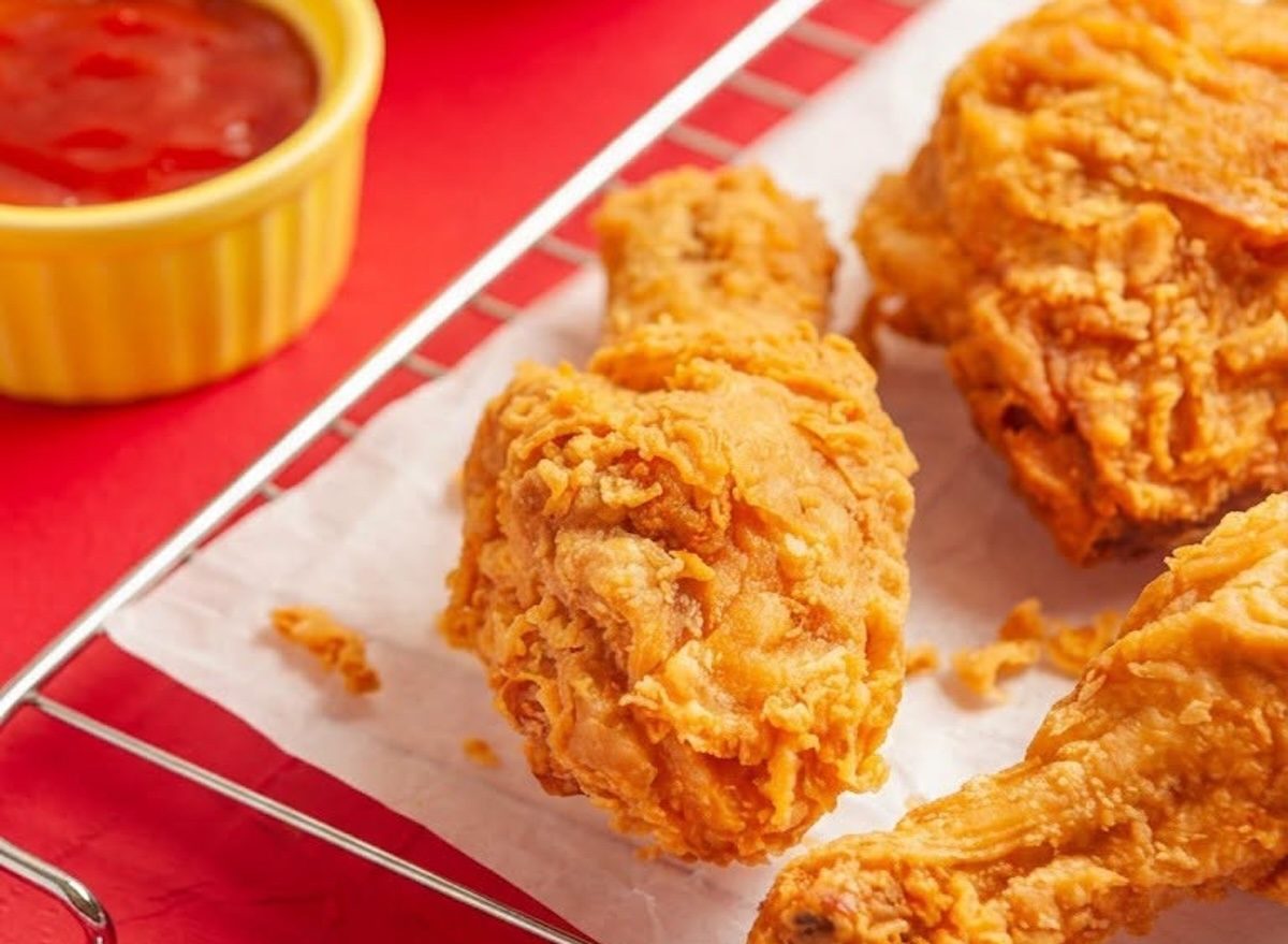 Prato com tiras de frango grelhado dourado ao lado de salada verde e fita métrica enrolada