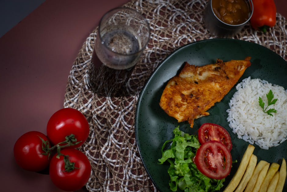 Peito de frango dourado e crocante ao lado de uma tigela de iogurte grego e temperos frescos sobre uma mesa rústica