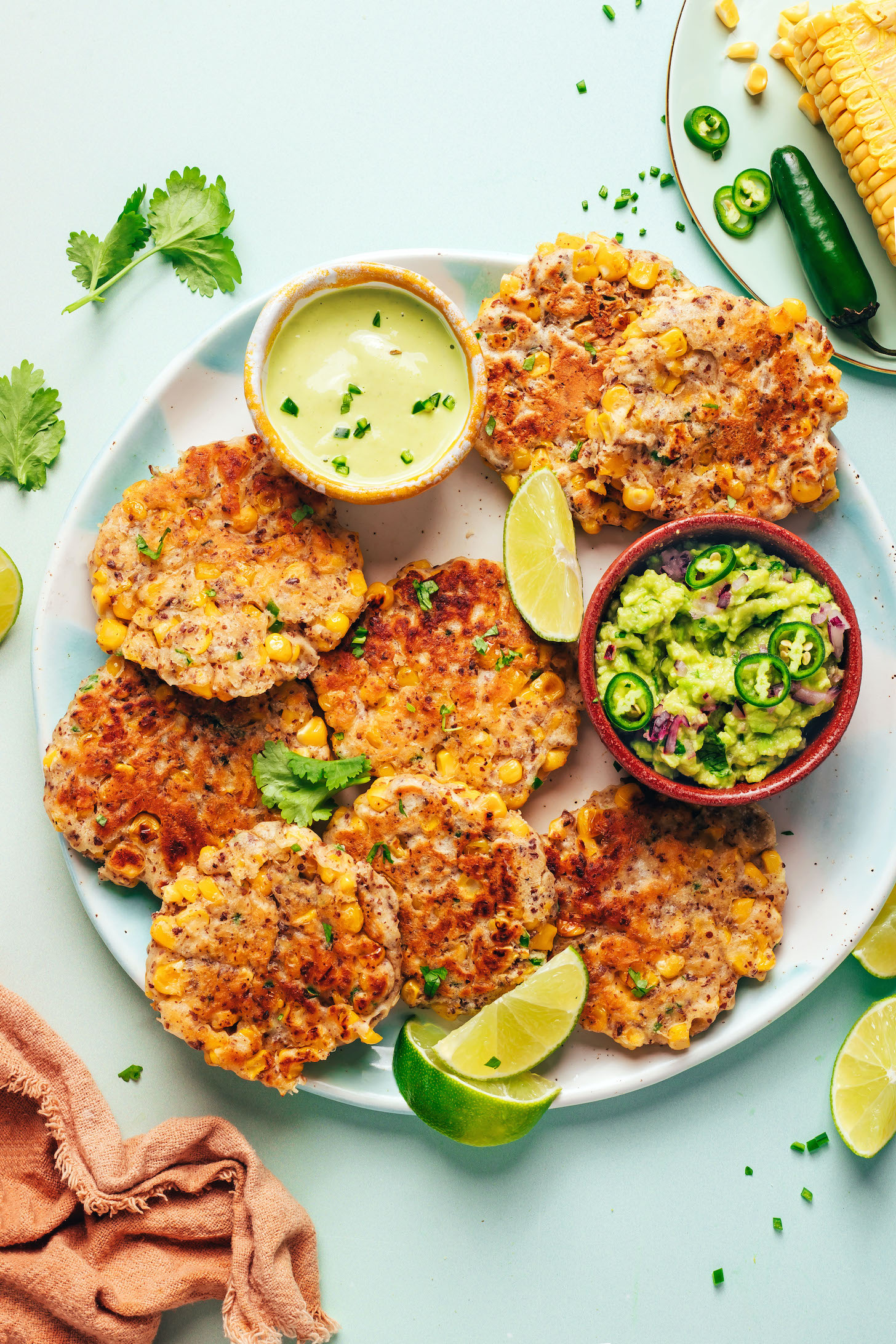 Uma fritura de milho em forma de coração, com um pedaço de guacamole ao lado e uma colher de sopa de linhaça à vista