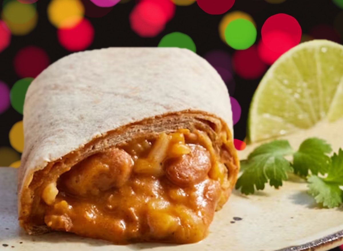 Pessoas saudáveis recheando burritos congelados com legumes e frango em uma cozinha bem iluminada
