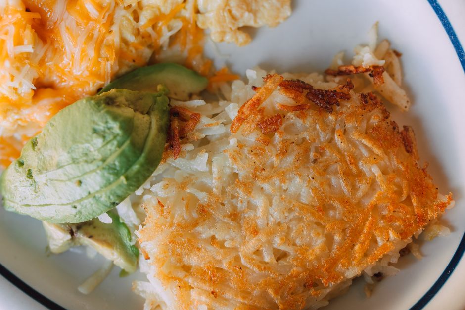 Hash browns crocantes, ovos cozidos e uma fatia de fruta fresca em um prato saudável