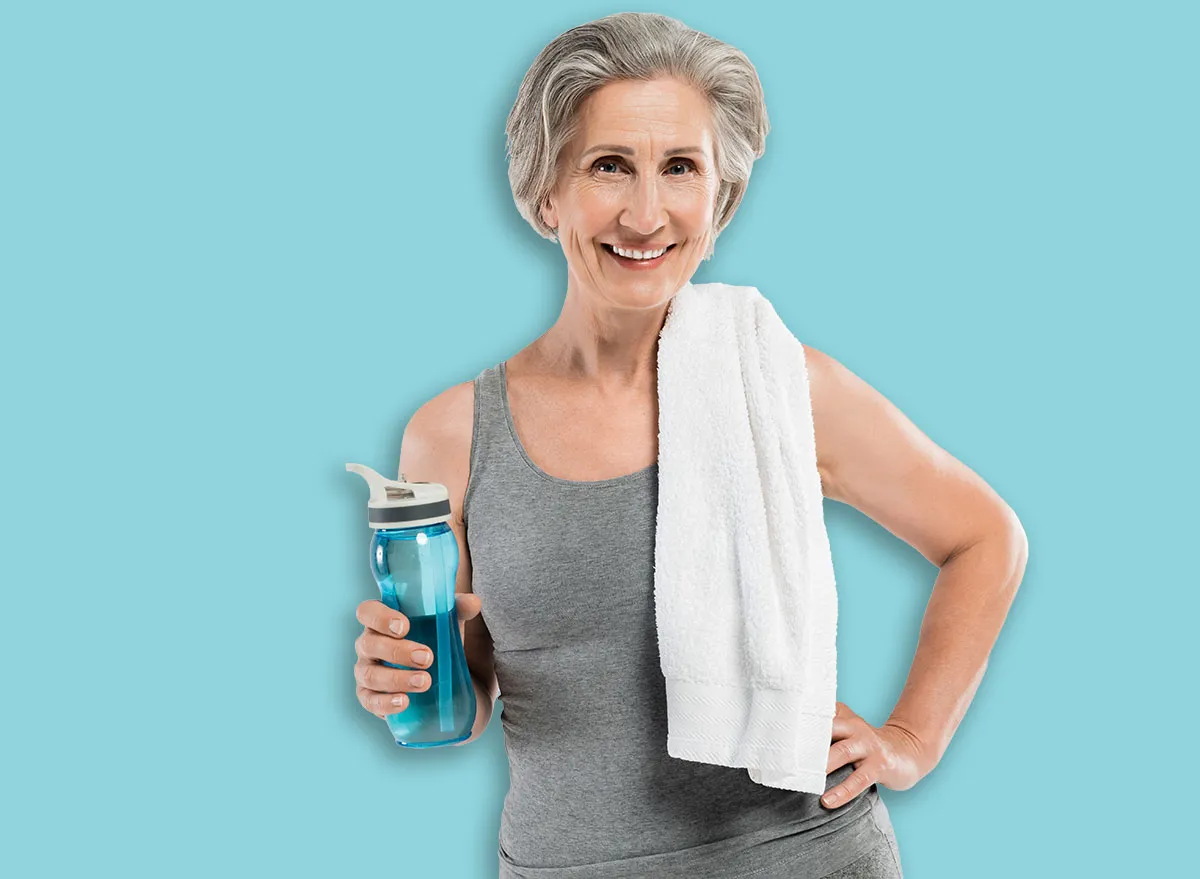 Uma mulher em pé na parede, realizando um exercício de elevação de coxa com um peso na mão