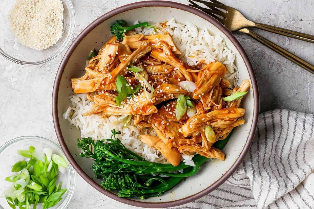 Um prato de frango grelhado com mel e alho, acompanhado de vegetais frescos e uma colher de sopa de iogurte natural