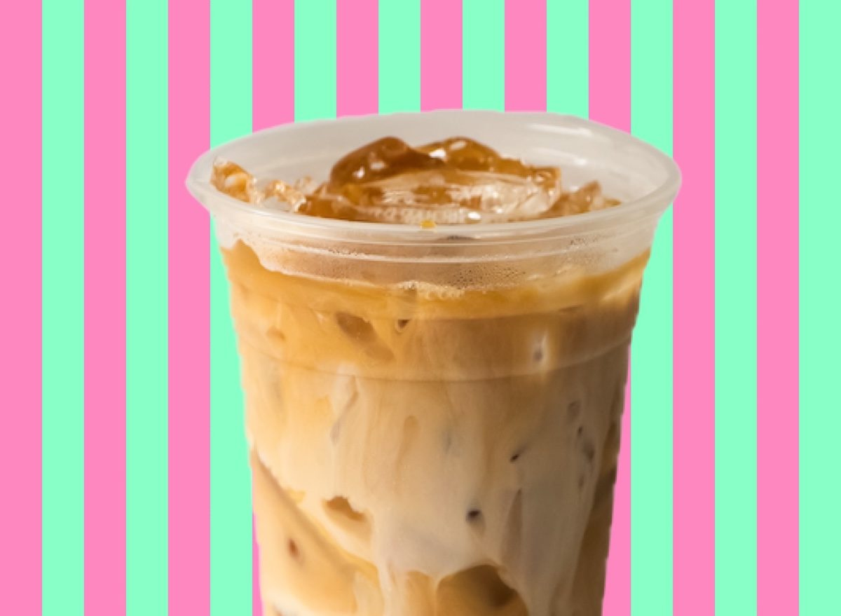 Uma xícara de iced coffee servida em um ambiente moderno, com gelo e frutas frescas ao redor