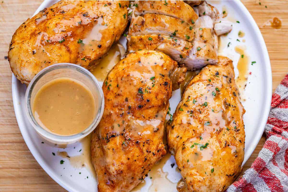 Um peito de frango suculento, coberto por um molho de cebola, em uma panela Instant Pot
