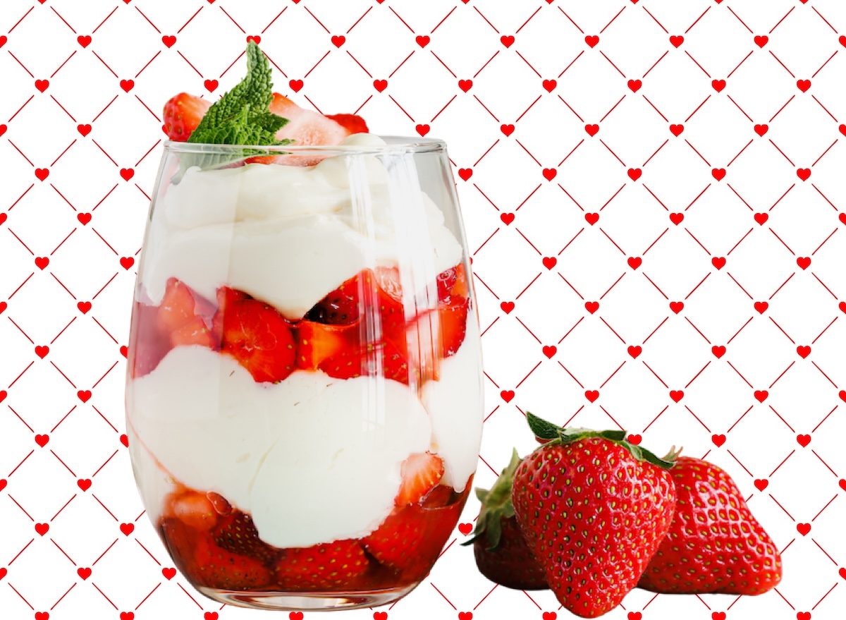 Um prato de iogurte branco, frutas vermelhas e granola em camadas sobre uma toalha de mesa limpa