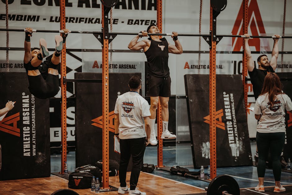 Atletas de CrossFit realizam levantamento de peso olímpico com barras e anilhas em uma arena de competição lotada