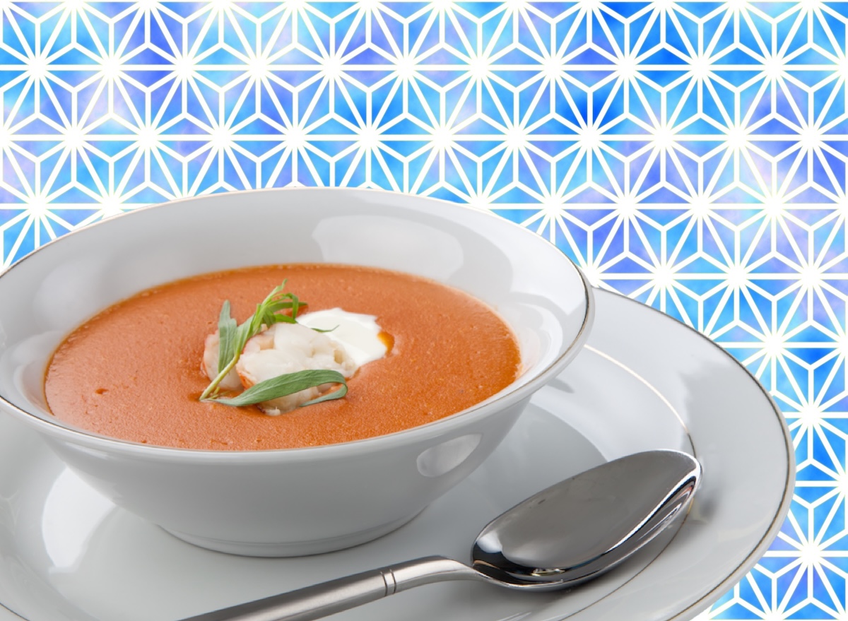 Uma tigela de sopa cremosa de lagosta com creme de leite e vegetais frescos