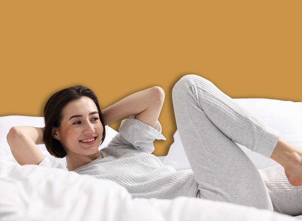 Uma pessoa deitada de costas com joelhos dobrados e pés apoiados na cama, realizando um movimento de contração abdominal