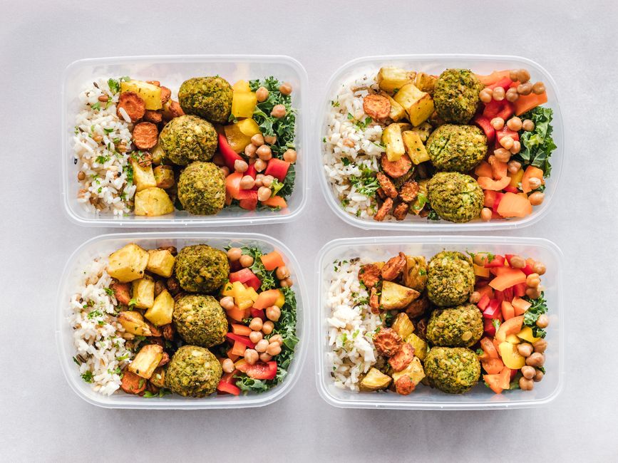 Um prato de frango grelhado acompanhado por legumes e arroz, completando uma refeição equilibrada